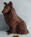 Escultura na forma de cachorro COLLIE em porcelana vitrificada na cor caramelo. Medindo 26 cm. OBS: Apresenta pequeno restauro em uma das patas.