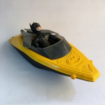 Boneco Batman emborrachado e articulado  com Batbarco em plástico. Exemplar parte de coleção. Dimensões: 60 cm (maior medida).