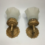 Antigo par de arandelas em bronze, ornados em arabescos com cúpulas em vidro satinado. Dimensões: 15 cm x 15 cm x 10 cm (cada).