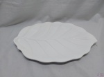 Travessa oval em porcelana branca na forma de folha. Medindo 49cm x 32,5cm x 3,5cm de altura.