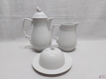 Jogo de servir chá café com 3 peças em porcelana branca com relevo. Composto de bule (fio de cabelo na tampa), leiteira e manteigueira. Medindo o bule 23cm de altura.