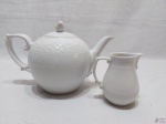 Bule de chá e cremeira em porcelana branca com relevo. Medindo o bule 23,5cm bico alça x 15cm de altura.