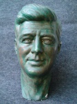 ESCULTURA. JOHN F KENNEDY - Busto em estuque. Assinado Antônio Geraldes. MedIdas. 43x29x27 cm. Pequenos lascados.