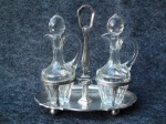 Galheteiro em prata italiana contrastada, pesando mais de 300g.  Garrafas em demi cristal, com discreto trincado no gargalo em 1 das garrafas. Medidas . 20x20x11,5 cm.  CX  7