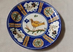 ANTIGO MEDALHÃO EM FAENZA POLICROMADA. Manises/Murcia - Espanha  Decorado com pássaro, rosáceas  estilizadas e flores. Assinado no verso M A. Possivelmente Séculos XVIII/XIX. Diâmetro 31 cm