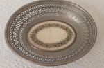 Cesta em FAENZA, guarnecida em metal. Numerada e marcada no fundo WMF. Início do século XX. Medidas 6x28x23 cm. Visível fio de cabelo. No estado