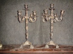 Par de elegantes candelabros para 5 velas em metal espessurado a prata. Med. 48x28x28 cm. Um dos recipientes diferentes. Desgastes no banho.