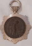 ARTE SACRA. Medalhão representando o ANJO DA GUARDA. Metal espessurado à prata, tendo o centro com rico acabamento em pátina escura. Brasil Século XX. Medidas 90x65 mm