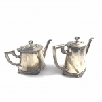 Conjunto de bule de chá e café em metal espessurado a prata da manufatura FRACALANZA, estilo lacinho. Em ótimo estado. Necessita de limpeza. Medidas: 16cm e 15cm.