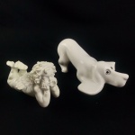 Lote com 2 ( duas ) esculturas em cerâmica na cor branca , sendo : 1 ( um ) de cachorro ( 20 cm / comprimento ) e 1 ( uma ) de anjinho ( 13 cm / comprimento ) . Em excelente estado de conservação .