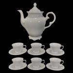 SCHMIDT - CONJUNTO PARA CAFÉ EM PORCELANA SCHMIDT NA COR BRANCA, COM BORDAS EM DETALHES EM ARABESCO EM ALTO RELEVO NA MESMA COR, SENDO UM BULE E SEIS XÍCARAS PARA CAFÉ. - MED BULE 22 X 24 CM.