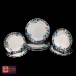 NOVE (4+3+2) PEÇAS EM PORCELANA BRANCA ESMALTADA, BORDAS COM FAIXA AZUL E DECORAÇÃO GEOMÉTRICAS EM TONS DE ROSA, AMARELO, VERDE, AZUL E DECORAÇÃO FITOMÓRFICAS,  SENDO QUATRO PRATOS RASOS, TRÊS PRATOS FUNDOS E DOIS PRATOS DE SOBREMESA - MED 27,5 CM, 20,5 X 4 CM, E 19,5 CM.