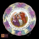 PRATO DECORATIVO EM PORCELANA SCHMIDT COM POLICROMIA E CENA CENTRAL DE ANGELICA KAUFTMAN - MED: 25 CM.