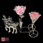 CANDELABRO PARA DUAS VELAS  EM VIDRO E METAL PRATEADO, REPRESENTANDO CARRUAGEM CONDUZIDO POR RENA, TRANSPORTANDO DUAS VELAS EM FLOR. MED: 21 X 8,6 X 26 CM.