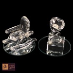 DUAS ESCULTURAS EM CRISTAL REPRESENTANDO CADEIRA DE BALANÇO E GRAMOFONE, EM BASE CIRCULAR ESPELHADA- MED TOTAL: 5 X 5 CM .