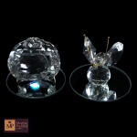 DUAS ESCULTURAS EM CRISTAL REPRESENTANDO TV E BORBOLETA, EM BASE CIRCULAR ESPELHADA- MED TOTAL: 4 X 5 CM E 5 X 3, 5 CM.