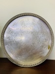 BANDEJA REDONDA EM METAL ESPESSURADO A PRATA COM BORDAS VAZADAS E APOIADA EM TRÊS PÉS  MED 6 X 41 CM.