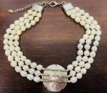 CHOKER COM 88 PÉROLAS BARROCAS E FLOR EM MADREPÉROLA. FECHO EM METAL PRATEADO. COMPRIMENTO ABERTO 35CM. 