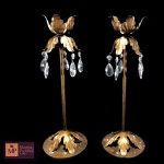 DOIS CASTIÇAIS EM METAL COM PATINA DOURADA, DECORAÇÃO FITOMÓRFICA E COM PINGENTES EM CRISTAL. - MED 35 X 12 CM.