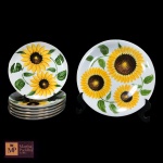 PRATO PARA BOLO COM SEIS PRATOS  EM PORCELANA NACIONAL NA COR BRANCA, PINTADA A MÃO, COM MOTIVOS DE GIRASSÓIS  E PEGAS E FRISOS DOURADOS ASSINADOS. ALGUNS APRESENTAM PERDA NA PINTURA.