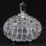 BOHEMIA - Belíssima bomboniere em cristal europeu translúcido estilo art deco finamente lapidado em tijolinho. Pega da tampa em forma de obelisco e apoiado sobre quatro pés facetados. Med: 18cm