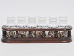 Belíssimo porta temperos com moldura em madeira nobre entalhada, galeria balaustrada, 06 recipientes em opalina branca leitosa decorada em policromia com os temperos. Med: 33 x 19 x 23cm