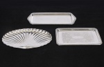 Lote composto por 03 peças em metal espessurado a prata finamente cinzelado sendo: uma bandeja retangular (26 x 16cm) uma bandeja retangular (Med: 33 x 14cm) uma petisqueira em forma de concha (med: 18 x 29cm)