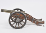 COLECIONISMO - Miniatura de canhão de procedência inglesa, em bronze dourado e finamente cinzelado  e madeira de lei, rodas deslizantes. Med: 31 x 14 x 13cm