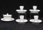 Lote composto por 04 peças em porcelana Francesa E. Borgois no tom branco finamente gomado com bordas filetadas a ouro sendo 04 porta ovos e uma molheira com tampa. (Pequeno bicado no presentoir)