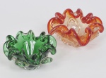 Lote composto por 02 cinzeiros de vidro de murano sendo um na cor ambar e o outro na cor verde com decoração em babados. Med do maior: 16 x 7cm