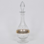Garrafa licoereira em cristal Europeu, lapidação em dedão, faixas em folha de ouro e base raiada. Med: 39cm