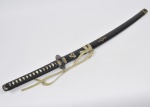 Réplica e antiga espada oriental com bainha e empunhadura em material sintético com aplicações em bronze dourado e cinzelado. Cabo com empunhadura a corda Med: 94cm