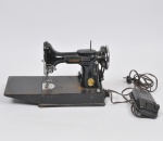 COLECIONISMO - Singer - Máquina de costura elétrica em metal patinado na cor preta, aplicações em metal prateado cinzelado, acompanha pedal - Motor funcionando, mecanismo necessita revisão - Metal Oxidado Med: 33 x 20 x 29cm Acondicionado em estojo