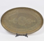 Grande bandeja oval em metal marroquino finamente cinzelado e esculpido a mão com elementos abstratos e acantos com borda com caneluras. Med: 74 x 47cm