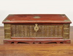 Baú indiano executado em madeira de lei patinada na cor vermelha e com aplicações em bronze dourado e cinzelado com elementos fitomórficos. Med: 120 x 56 x  45cm