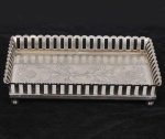 Bandeja retangular em metal espessurado a prata com cercadura alta vazada e apoiada por 4 pés esfera. Med: 29 x 20cm