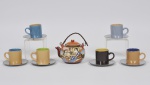 Lote composto por 07 peças em cerâmica esmaltada bule pra café decorado com paisagem em relevo (9cm) e 06 canecas para cafezinho com pires em metal cinzelado. Med: 5cm