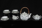 Parte de serviço para chá em porcelana oriental decorada em policromia com flores, rosáceas e gueixas, alça do bule em ratan. Composto por Bule de chá, açucareiro e 3 xícaras para chá com pires