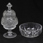 Lote composto por: Bomboniere em cristal  europeu ricamente lapidada com geométricos, palmas, treliças e losangos Tampa com pega em forma de pinha e base raiada. Altura: 30cm (Bicados na tampa) e um centro de mesa em cristal lapidado frisos e caneluras. Med: 20 x 8cm