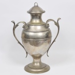 Grande Refresqueira em forma de Ânfora em metal espessurado a prata cinzelado, Bojo Liso, Alças no feitio de acantos, tampa com pega em forma de argola. Med: 70cm
