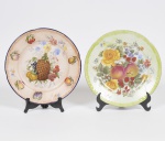 Lote composto por 02 pratos de coleção em porcelana europeia, decoração em policromia com flores e frutos. Med: 24cm
