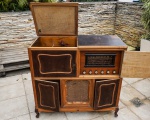 COLECIONISMO - ELETRONMATIC - Antigo radio vitrola da década de 1950 em metal e material sintético acomodado em um elegante móvel no padrão peculiar da época em madeira de lei, auto falantes com revestimento de proteção em tecido e pés estilo francês (Sem garantia de funcionamento)  Med: 101 x 45 x 94cm