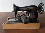 Antiga e bela máquina de costura, da marca Singer, acomodada em maleta de madeira , acompanha manual. Medidas: 43x20x30 cm - Lote nao testado.