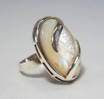 Grande anel encimado por cabuchon oval em Madrepérola e frisos em prata de lei. peso: 13.5 gramas , aro 23.