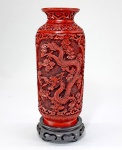 Vaso em laca chinesa, na cor vermelho Cinnabar, profusamente esculpido e decorado com dragões e nuvens. Séc.XIX.  Medida total 22 cm.