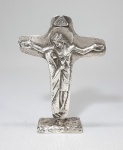RB - Antigo crucifixo estilizado em estanho revestido com folha de prata e pequena pedra branca. Assinado RB. numerado. Med. 14 x 10 cm.