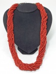 Comprido colar oriental torcido em pequenos contas de coral vermelho. Med. 70 cm