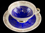 BAVARIA - ALEMANHA - Belíssima Chávena e seu respectivo pires, executado em fina porcelana alemã, na tonalidade azul real, com farta aplicação em rendilhados em ouro na borda, com a marca da manufatura na base. Dimensões: 6 cm X 10 cm. lxxx