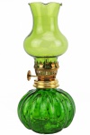 Lindo Lampião, executado em vidro verde e guarnição em metal dourado, sendo a base em decoração no padrão gominho, com pavio para acendimento. Altura: 19 cm. xxii