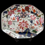 Travessa de forma retangular e cantos chanfrados de porcelana Companhia das Índias pertencente ao serviço conhecido como Folha de Chá. Ornado com esmaltes brilhantes na cor coral, verde, rosa e azul, aprimorado com ouro com decoração floral. China. Qing (1644-1912). Reinado Qianlong (1736-1795). 46 x 37 cm.